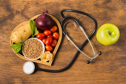 a collection of healthy foods alongside a stethoscope, symbolizing the connection between nutrition and health
